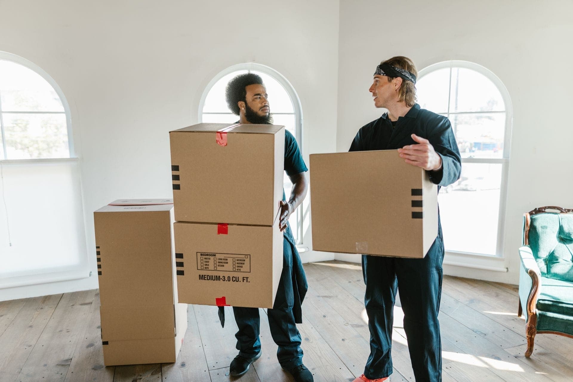 Removal crew carrying boxes into a new home